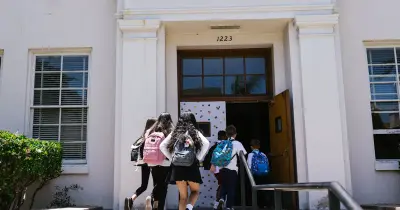Students with backpacks heading back to school in autumn