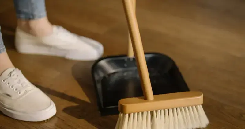 Person mopping hardwood floors during a thorough deep cleaning session