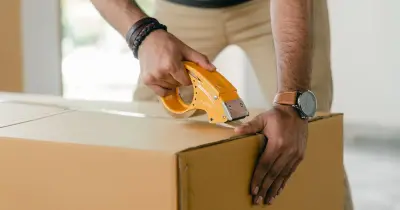 Person labeling and organizing moving boxes by room