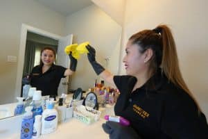 Residential Cleaning 1 A SparkTex Cleaners employee cleans a bathroom mirror.