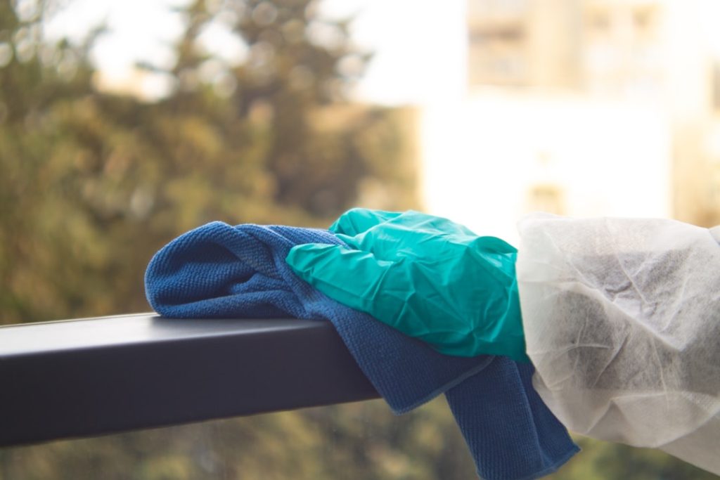 Hand cleaning railing with cloth