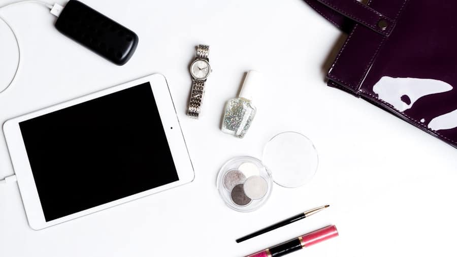 Flatlay of tablet, watch, makeup, and purse; modern woman's essentials.