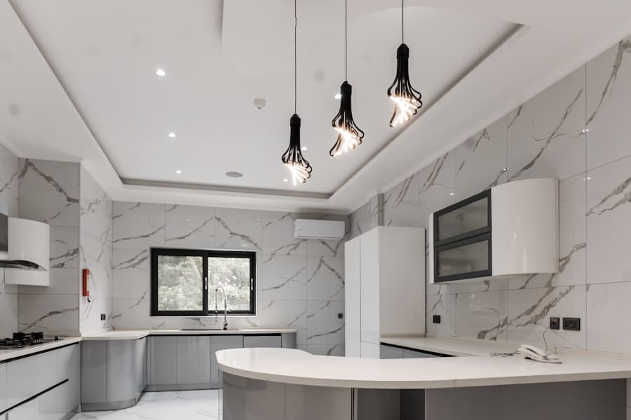 Modern luxury kitchen with marble tile backsplash and gray cabinets.