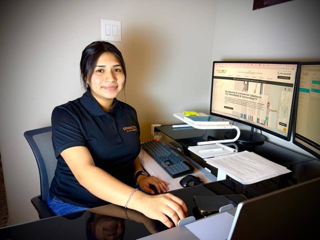 Spark-Tex Cleaners owner at her desk, working on a computer showing the company website. Residential and Commercial Cleaning Services Cleaning in Conroe and Woodlands Texas