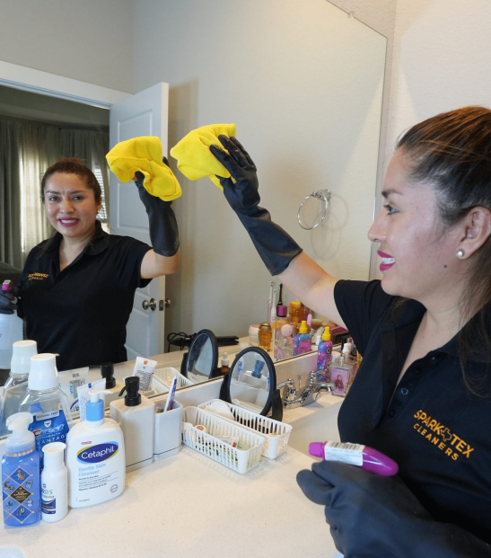 Cleaning Image Cleaning professional in Conroe/Woodlands, TX, cleaning a bathroom mirror.